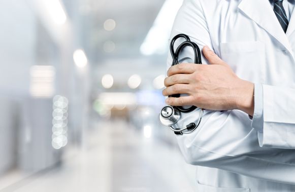 Doctor with a black stethoscope on hospital background